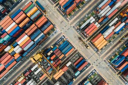 Luftaufnahme eines Containerhafens mit verschiedenen farbigen Containern.