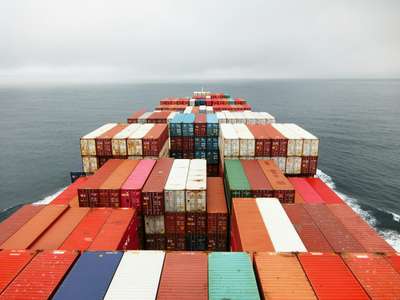 Container ship with brightly colored containers on the ocean, illustrating fast and minimal Python Docker container images build using uv